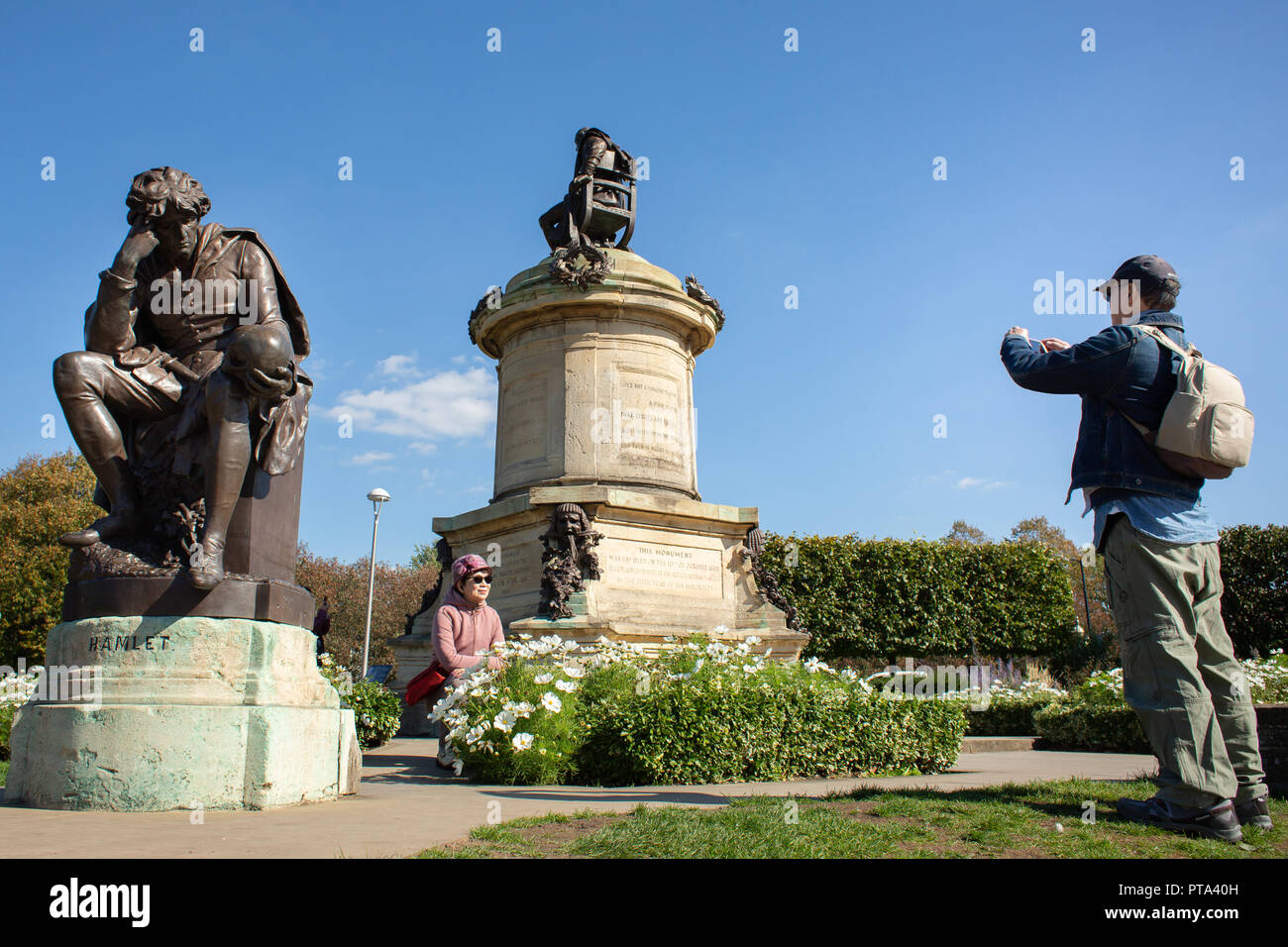 Ausländische Besucher rund um das Gower Memorial in Bancroft Gärten posieren. Die Statuen sind Shakespeare und die Aufmerksamkeit der Besucher anziehen. Stockfoto