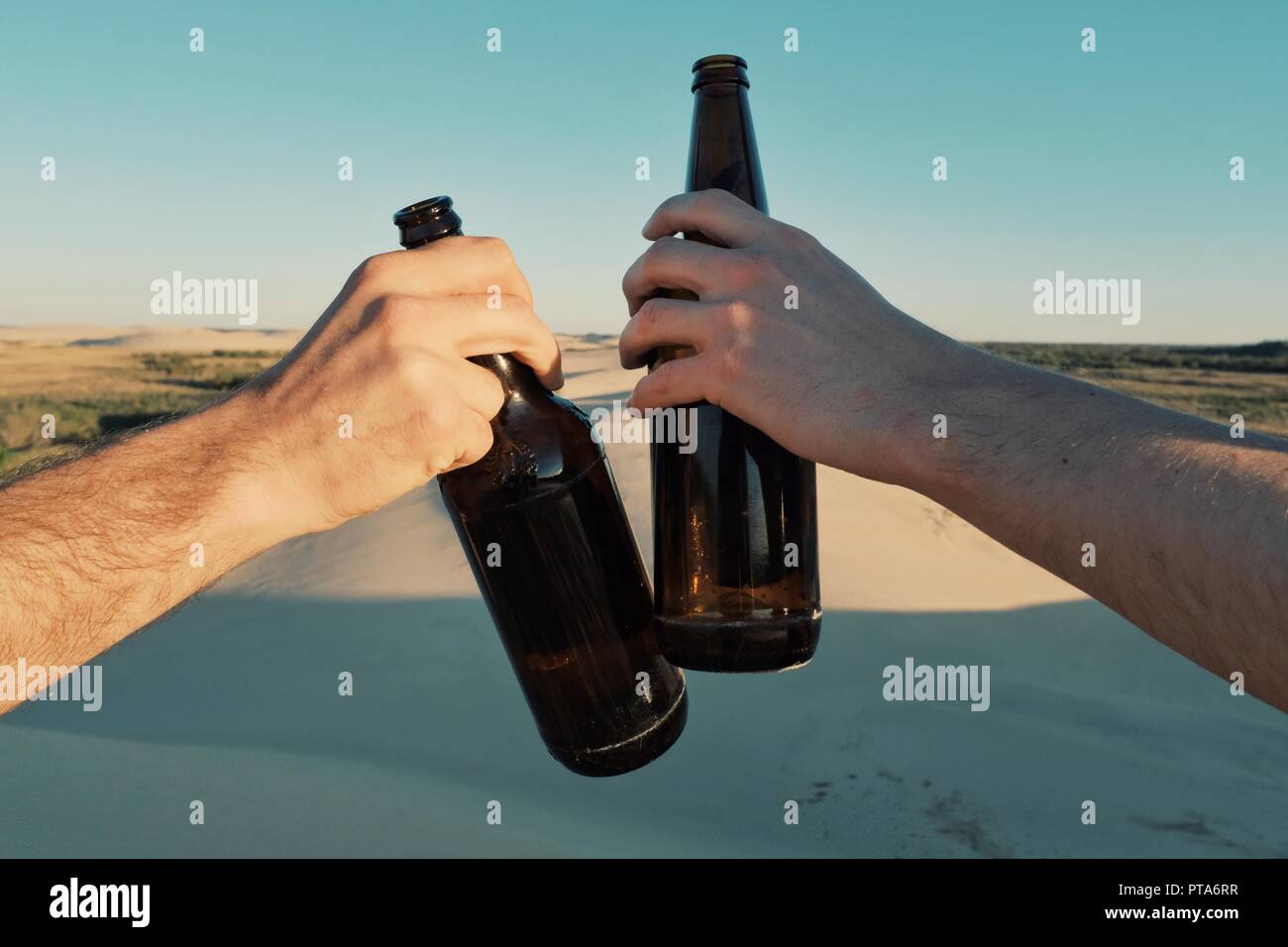 Santa Cruz, Bolivien - Sept. 5 2018: Zwei junge Mann klirren Bier Flaschen Bier in der Wüste Lagune Stockfoto