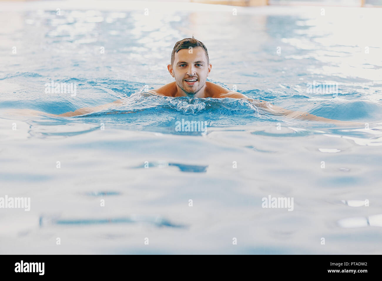 Ein stattlicher Mann in einem großen Pool zu Hause Stockfoto