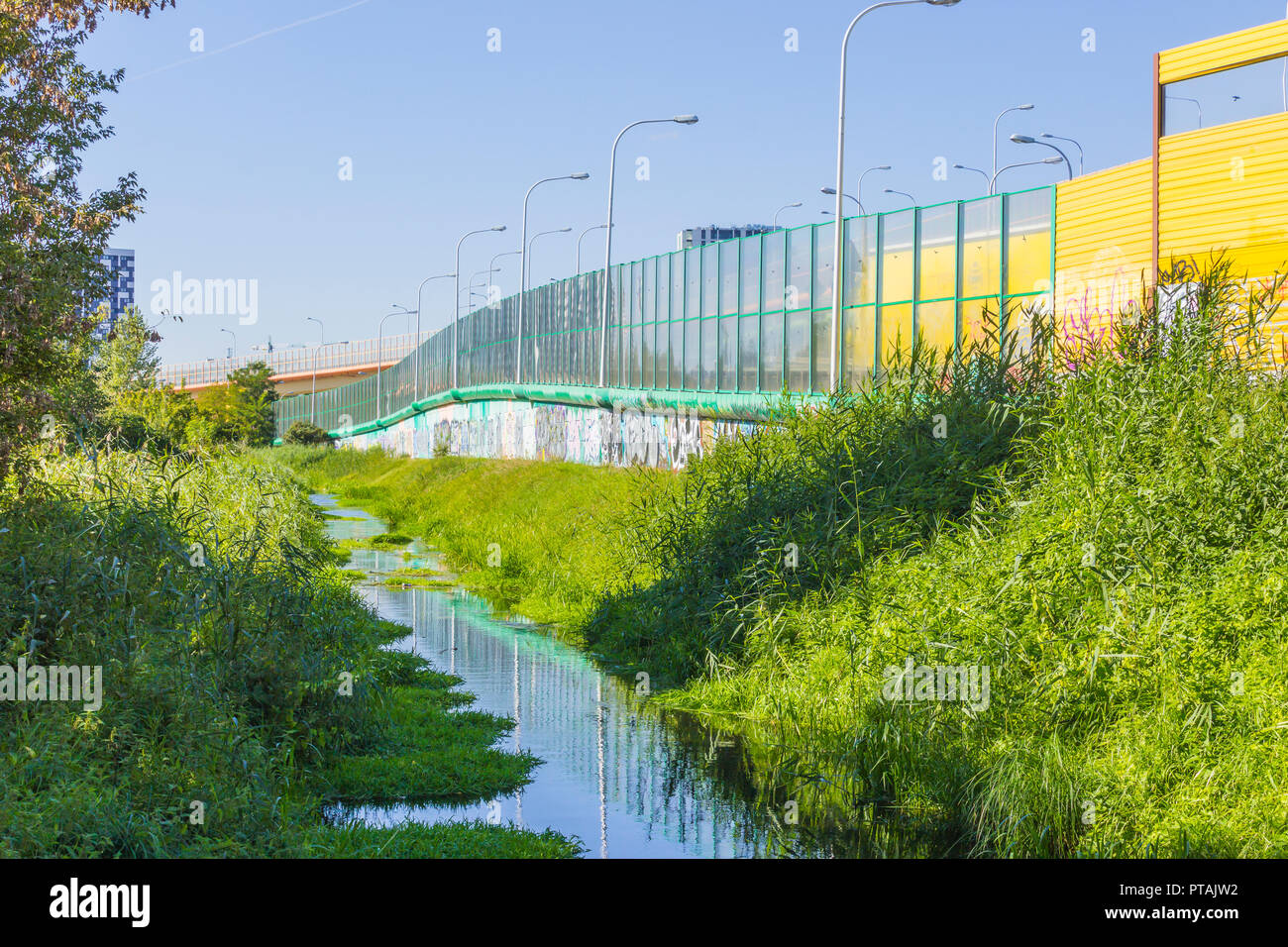 Schallschutzhaube Bildschirme entlang der Autobahn und den Creek. Metallrahmen mit Glas und gelbe Klang gefüllt-absorbierenden Verkleidungen. Moderne Technik in Polen. Stockfoto