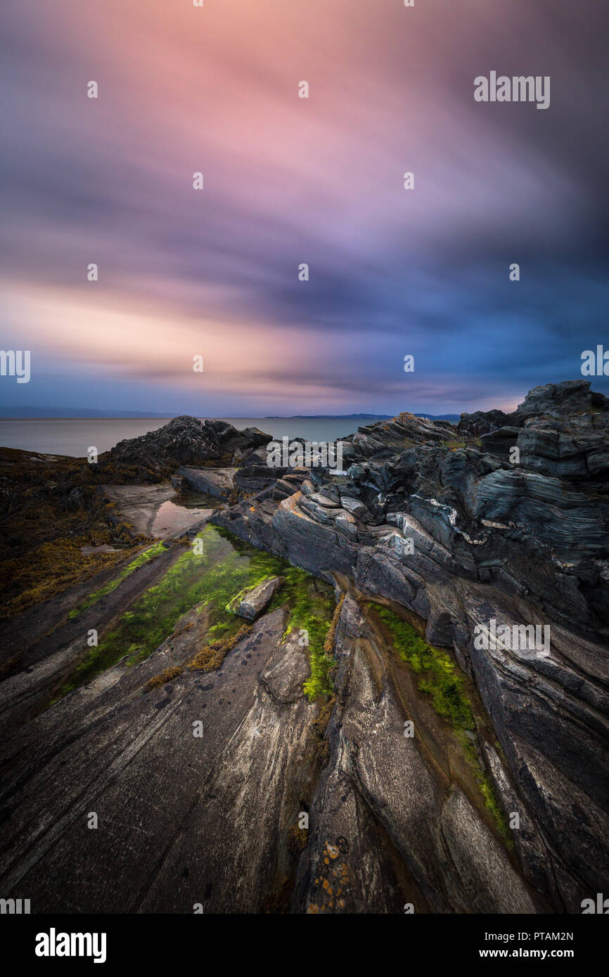 Sonnenuntergang von den Trondheimsfjorden, Strand in Vaeresholmen, Vaere. Lange Belichtung auf fließende Wolken und welligen Wasser. Stockfoto