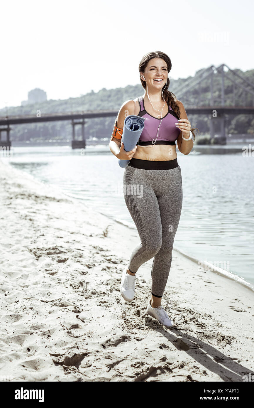 Schöne Frau mit einem Yoga Matte begeistert Stockfoto