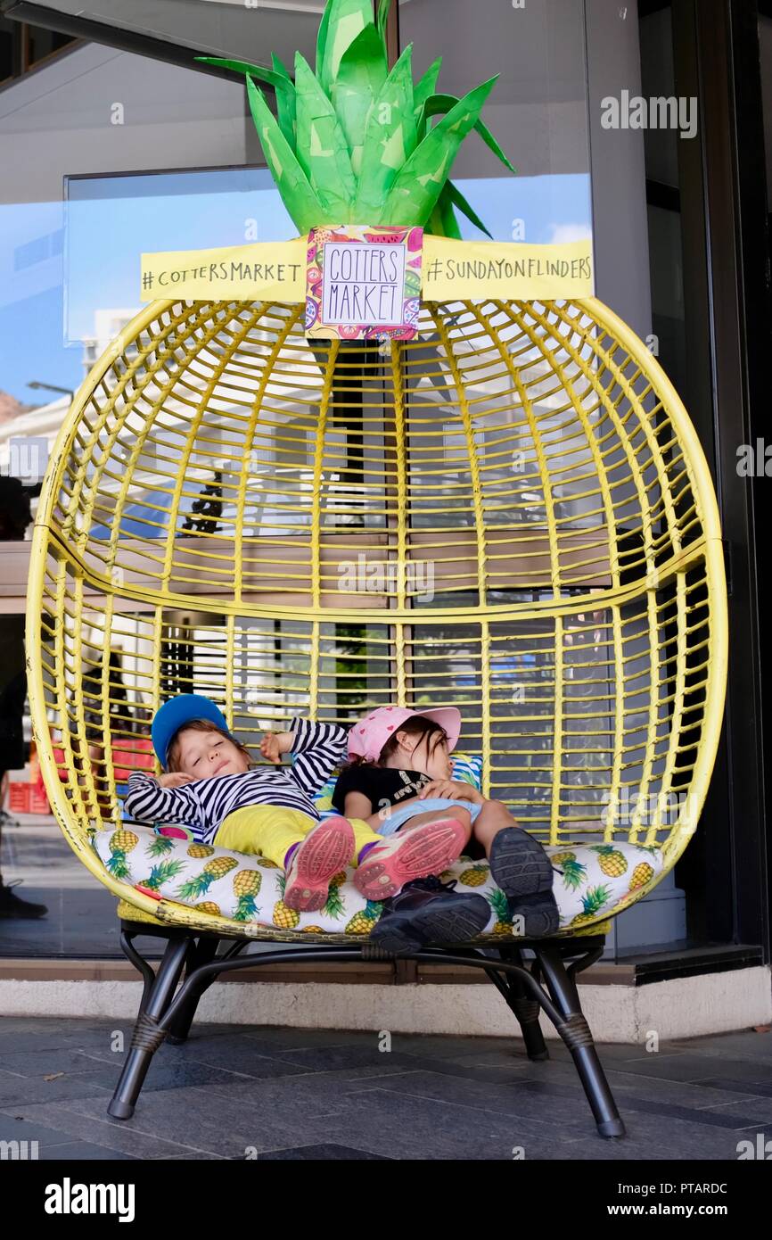 Kinder sitzen und entspannen in einem großen Ananas Stuhl, Splinte Markt an der Flinders Street, Central Business District der Stadt Townsville, QLD, Australien Stockfoto