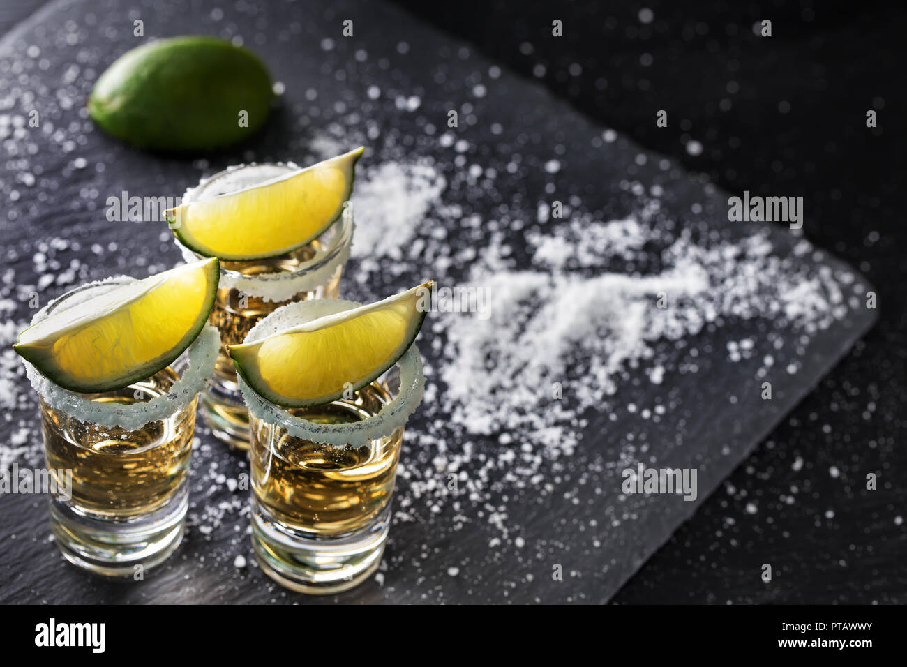 Golden tequila auf schwarzem Hintergrund. Alkoholfreien Cocktail. Mexikanische traditionelle Getränk Stockfoto