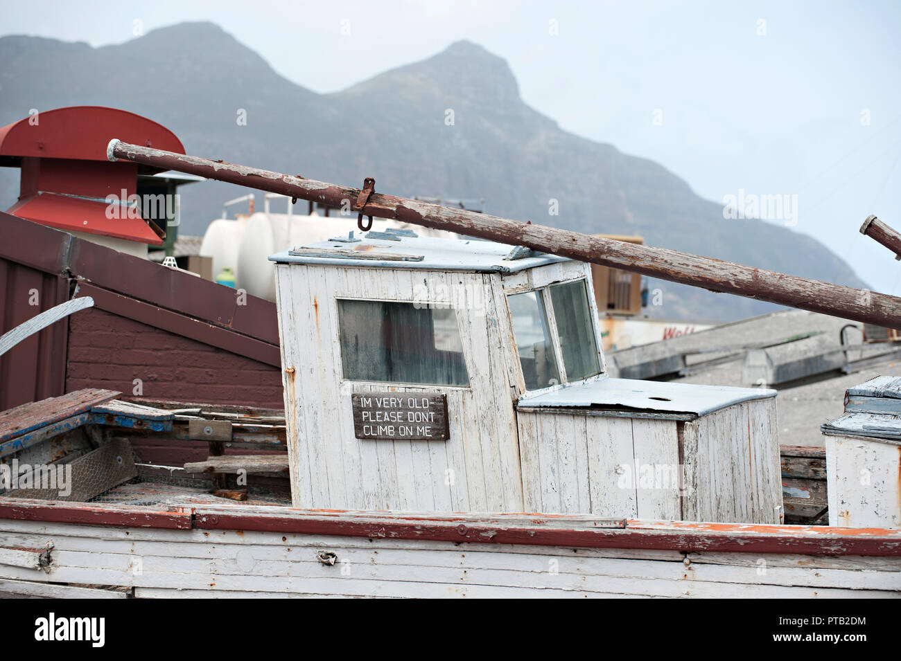 Ein zur Verschrottung altes Boot ist mit einem lustigen Meldung ich bin alt Bitte nicht klettern auf mir, in Hout Bay, Kapstadt, Südafrika Stockfoto
