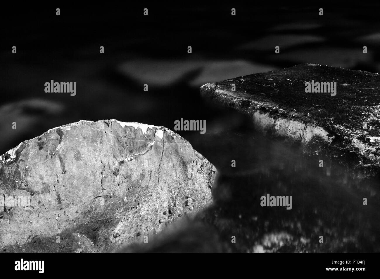 Schwarz und Weiß, monochrom, Abstract, Nacht Zusammensetzung der Steine im Wasser. Schwärze und Atmosphäre der Ruhe in der felsigen Landschaft. Stockfoto