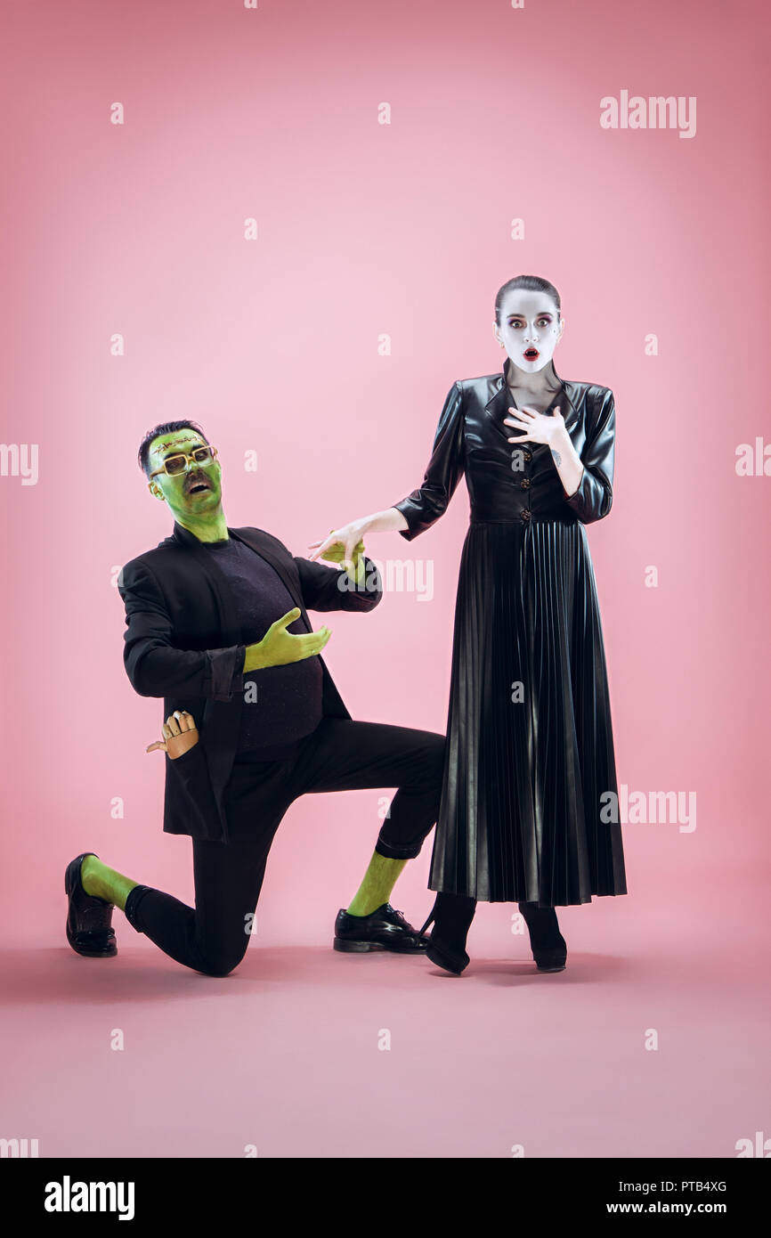 Halloween Familie. Glückliches Paar in Halloween Kostüm und Make-up.  Blutige Thema: Die verrückten maniak Gesichter auf Pink Studio Hintergrund  Stockfotografie - Alamy