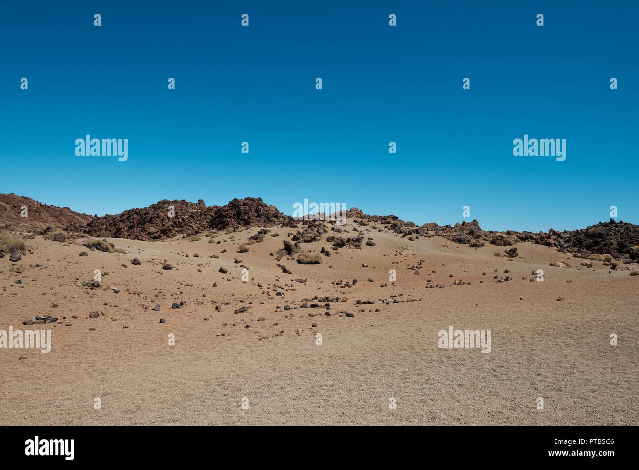 Wüstenlandschaft mit vulkanischen Felsen und dem klaren, blauen Himmel Platz kopieren Stockfoto