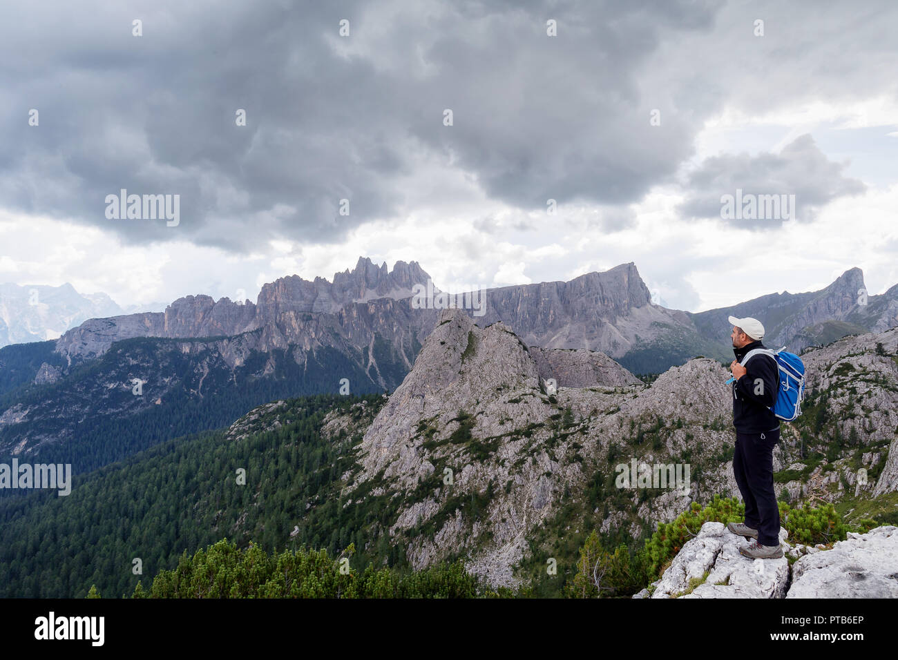 In der wunderschönen alpinen Landschaft eingebettet, ein Mann bewundert die hochalpine Landschaft mit Bergen und bewölktem Himmel. Stockfoto