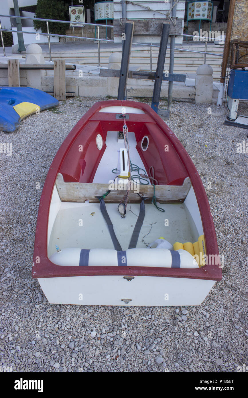 Weiß Rot Boot am Ufer in der Nähe des Hafens. Stockfoto