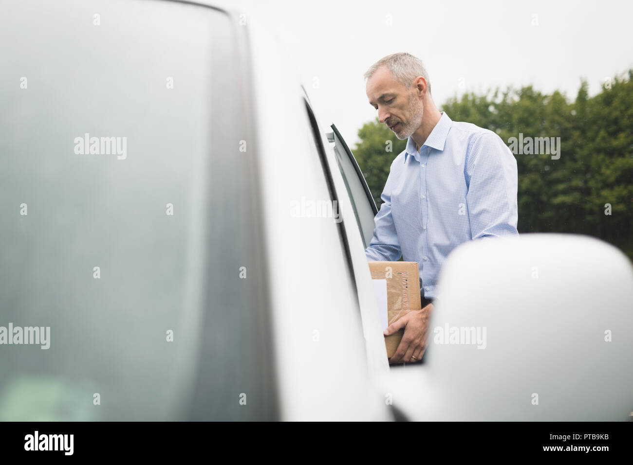 Delivery Man entladen Paket von Lieferwagen Stockfoto