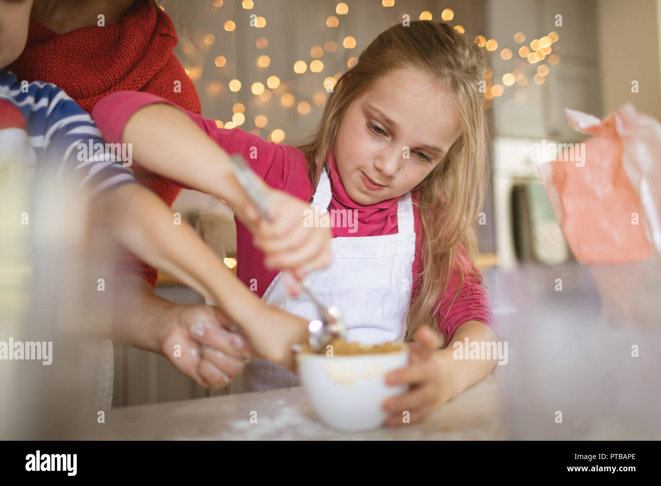 Mädchen mischen Sie die Zutaten in den Becher Stockfoto