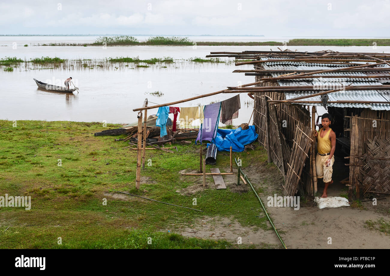 Überschwemmungen entlang der Brahmaputra Flusses bedrohlich Hütten und Menschen während des Monsuns in der Nähe von Jorhat, Assam, Indien zu verschlingen. Stockfoto
