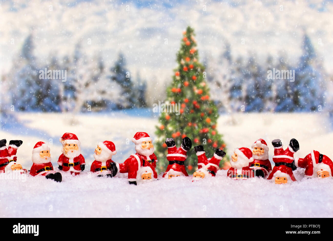 A large number of Santa Claus figures in front of winter landscape with Christmas tree Stockfoto
