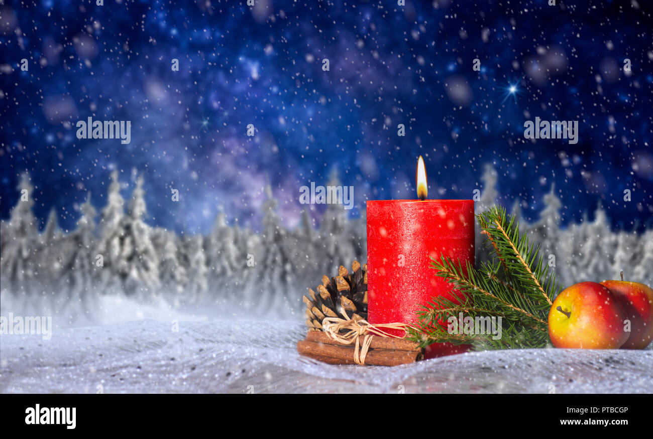 Rote Kerze mit Weihnachtsdekoration, Winterlandschaft, Sternenhimmel mit Schneefall und Kopie Raum Stockfoto