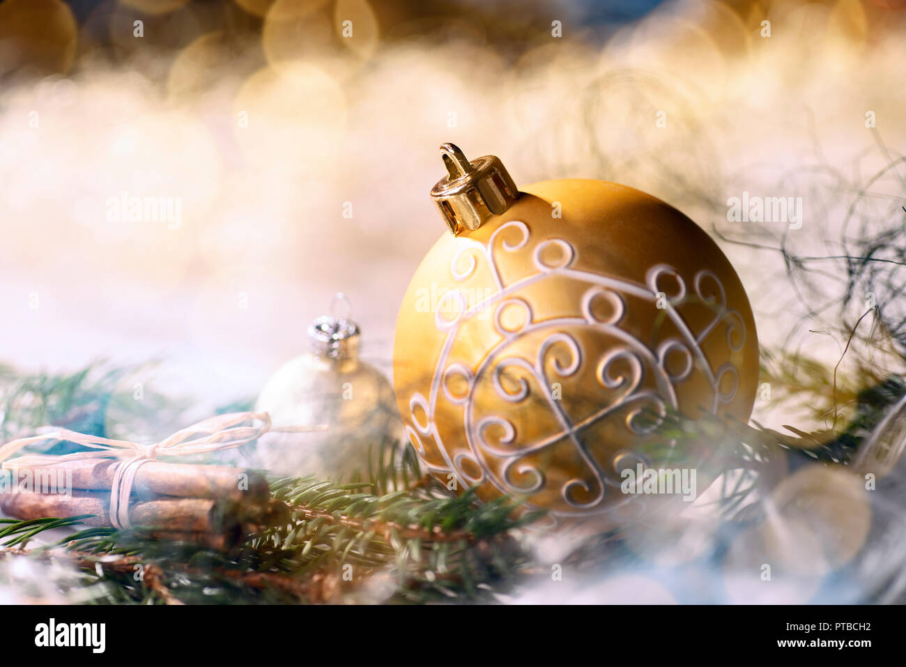 Goldene Christbaumkugel und Weihnachtsdekoration mit Tannenzweigen Stockfoto