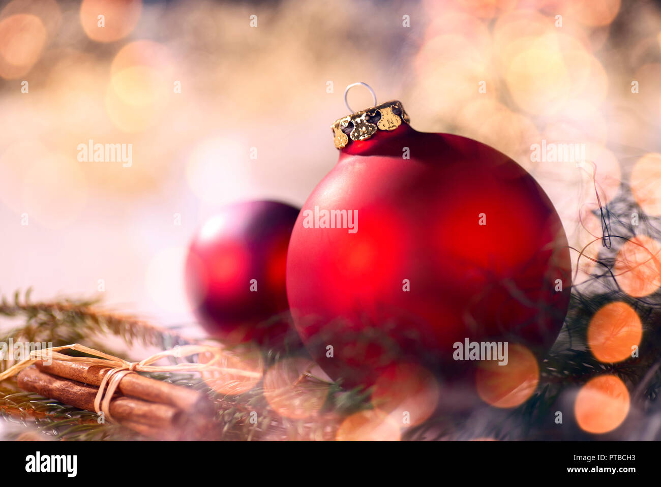 Rote Christbaumkugeln und Weihnachtsschmuck mit Tannenzweigen und Bokeh Stockfoto