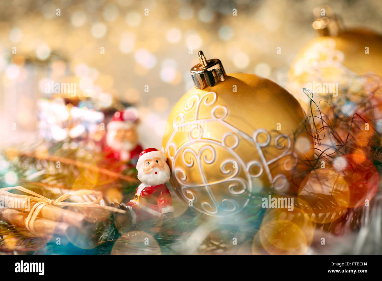 Goldene Christbaumkugel mit Weihnachten Dekoration und kleine Figur als Santa Claus Stockfoto