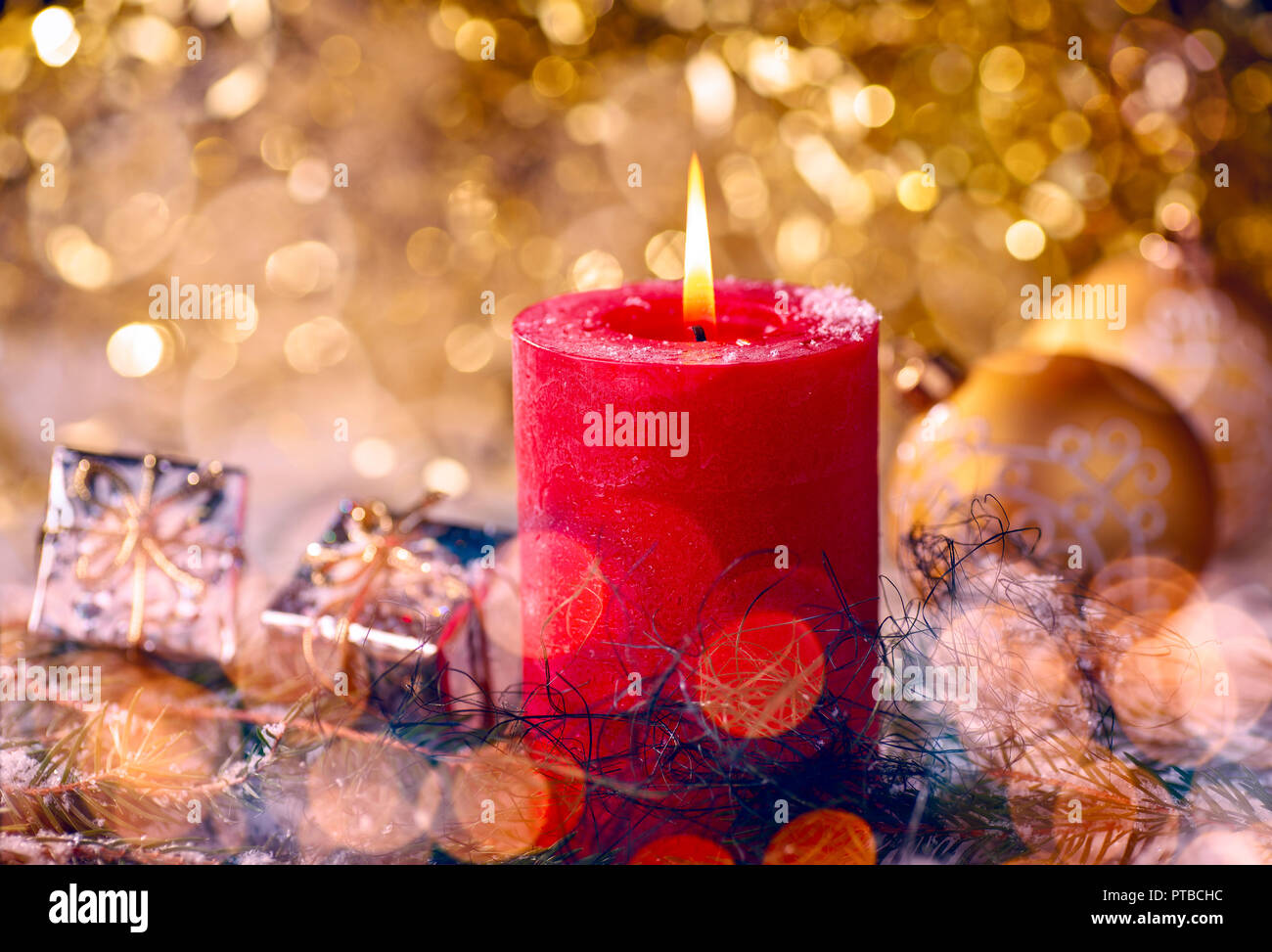 Rote Kerze mit Weihnachtsschmuck und Geschenkpaket Stockfoto