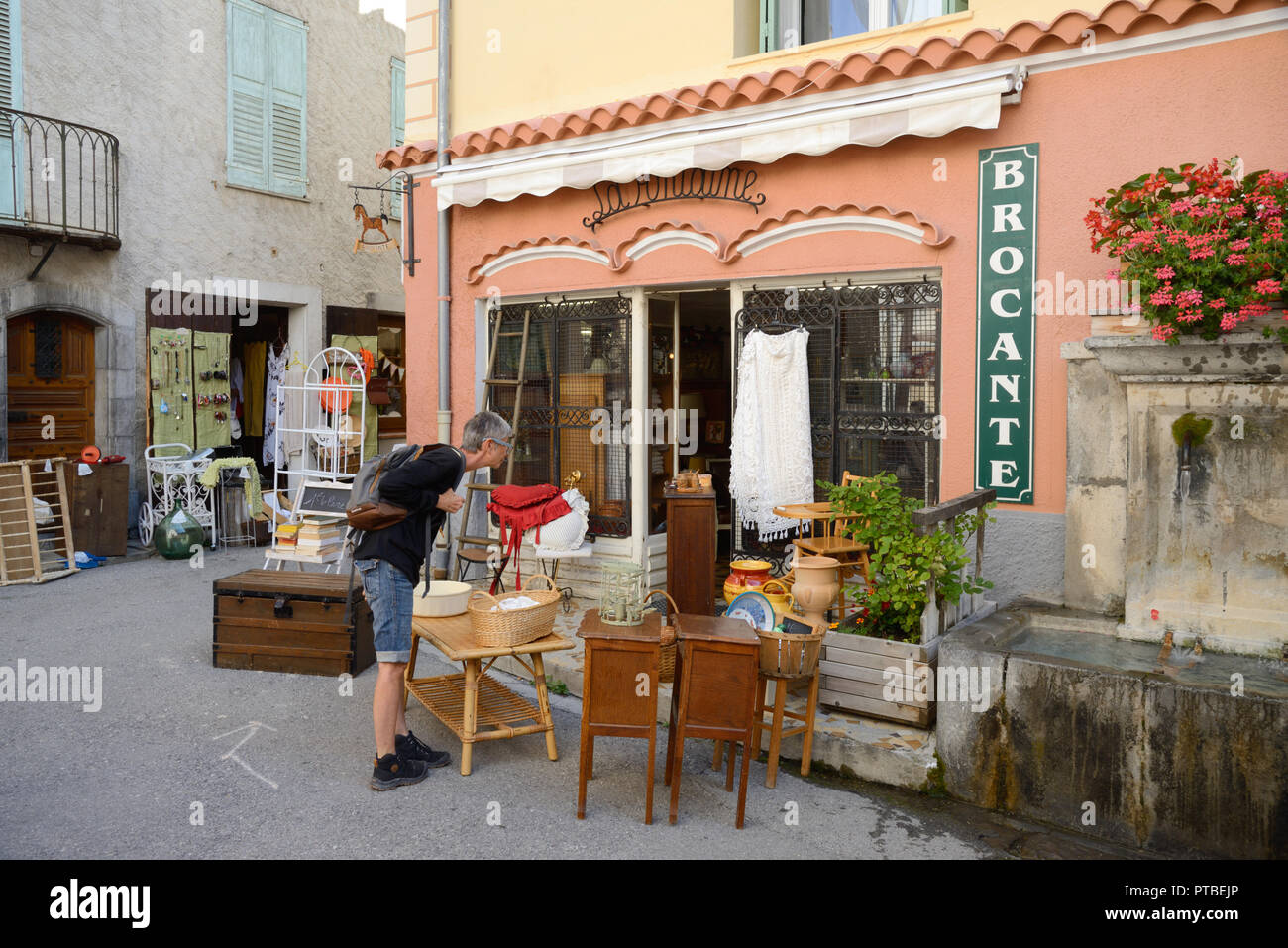 Frau Surfen zwischen Antiken auf, Außerhalb des antiken Shop oder Brocante Colmars-les-Alpes Provence Frankreich Stockfoto