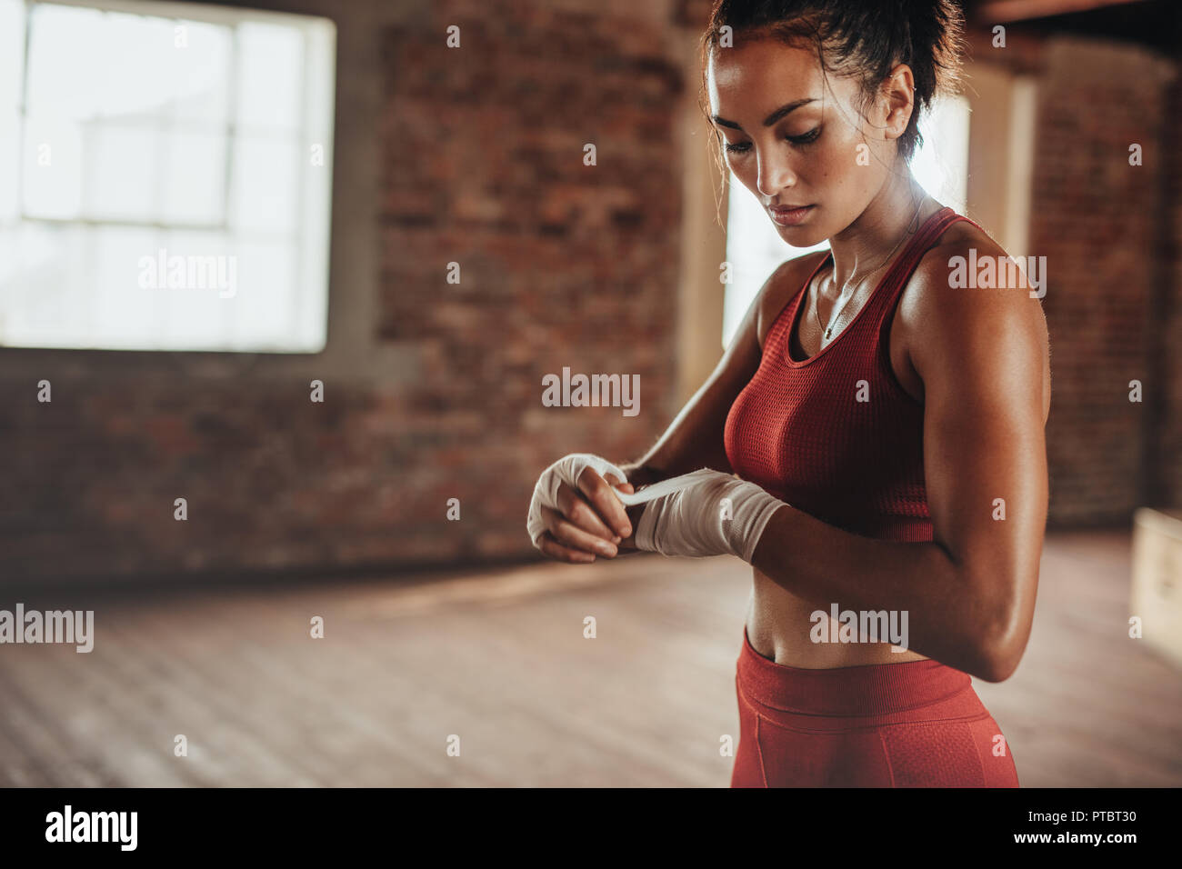 Gesunde junge weibliche Boxer tragen Armband am Handgelenk. Muskulös gebaut, Frau Bereit für Boxen im Fitness Studio. Stockfoto