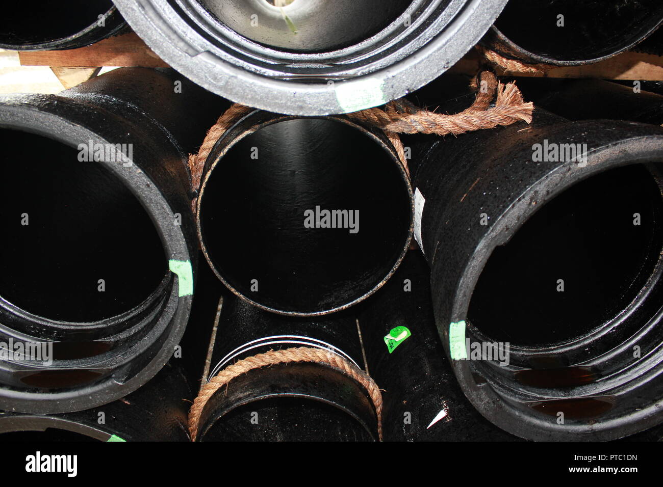 Langlebig und riesige schwarze Kunststoffrohre, die vor Kurzem geliefert wurden und sind für die ordnungsgemäße Platzierung bereit. Stockfoto