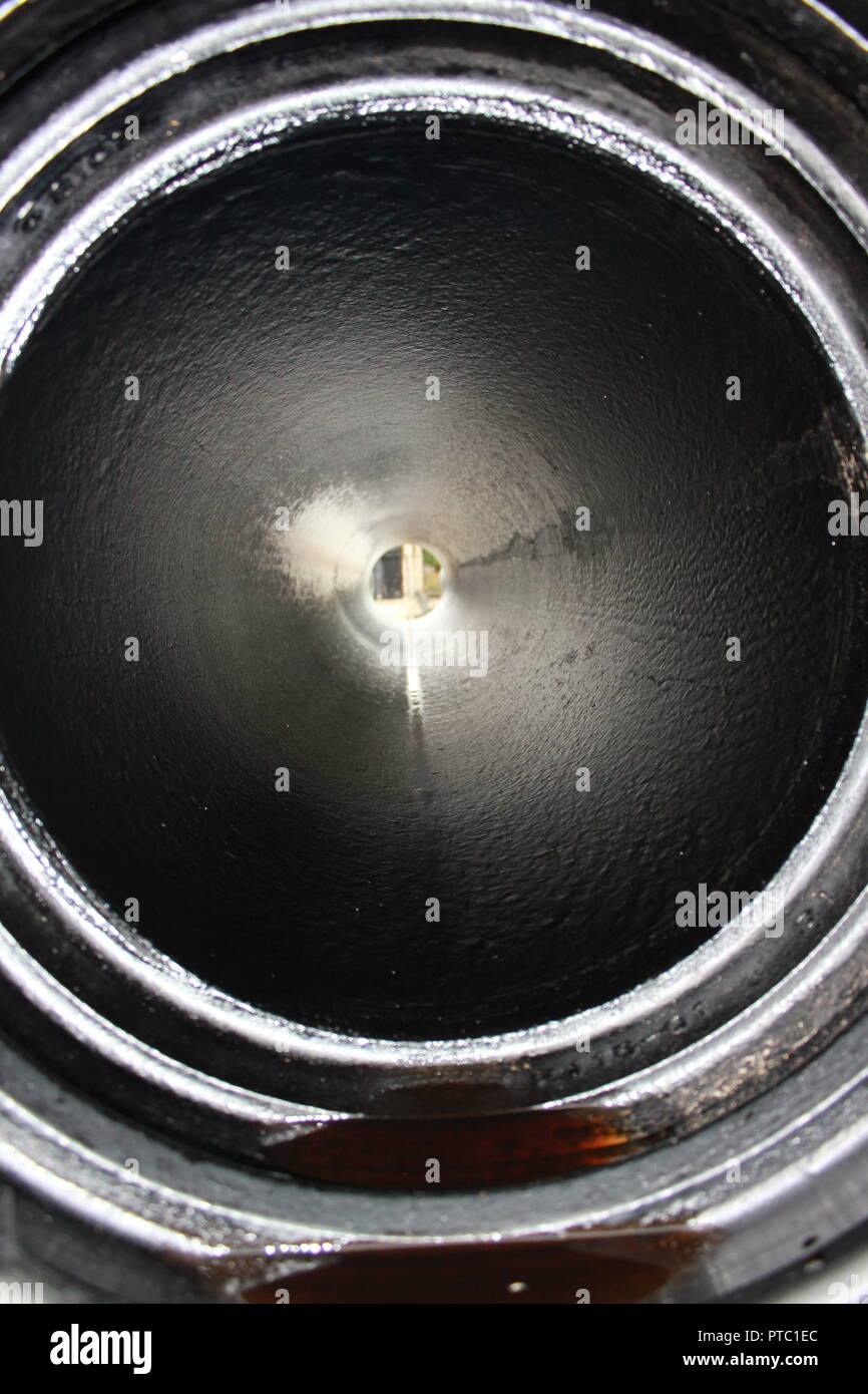 Suchen innerhalb einer langen schwarzen Rohr mit Licht am Ende der Zeile. Stockfoto