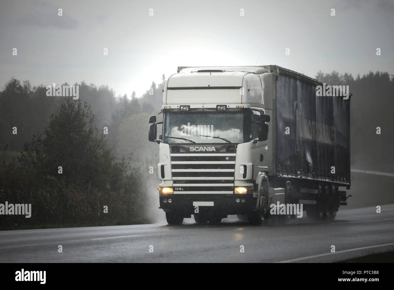 Salo, Finnland - 28 September 2018: Weiße Scania 114 L Auflieger transportiert Waren entlang der Autobahn bei schlechtem Wetter bei starkem Regen. Stockfoto