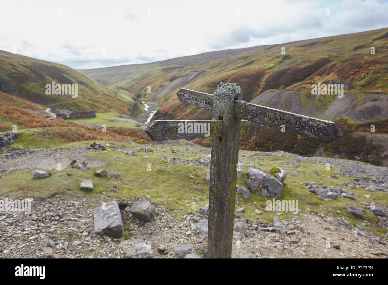 Fußweg zeichen Brücke und Blakethwaite Dämme in der Nähe der Überreste der einst blühenden führen Bergbau aufzugeben, Teil der Buntung Mine, Gunnersi Stockfoto