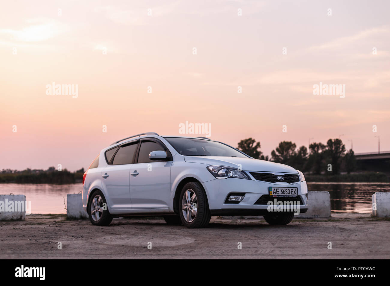 NOVOSELIVKA, DNIPROPETROVSK REGION, UKRAINE - September 01, 2015: Kia Ceed KOMBI Farbe Weiß in der Nähe von Samara FLUSS MIT BRÜCKE in der Dämmerung Stockfoto