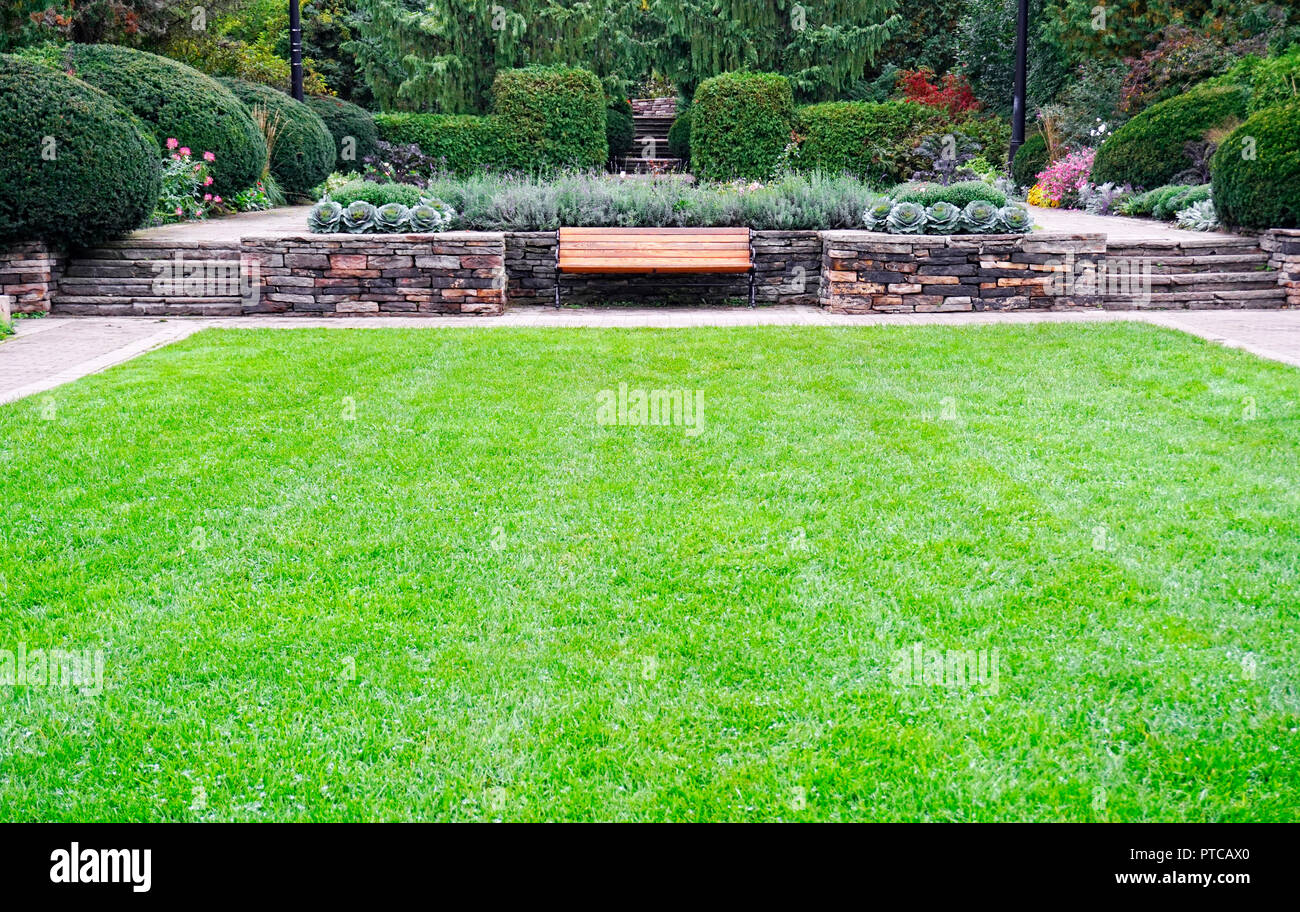 Garten Design mit stoneworks, Blumenbeete, mehrjährige Blumen, Rasen, Hecken und Bäumen in Alexander Muir Memorial Park im Norden von Toronto, Ontario, Stockfoto