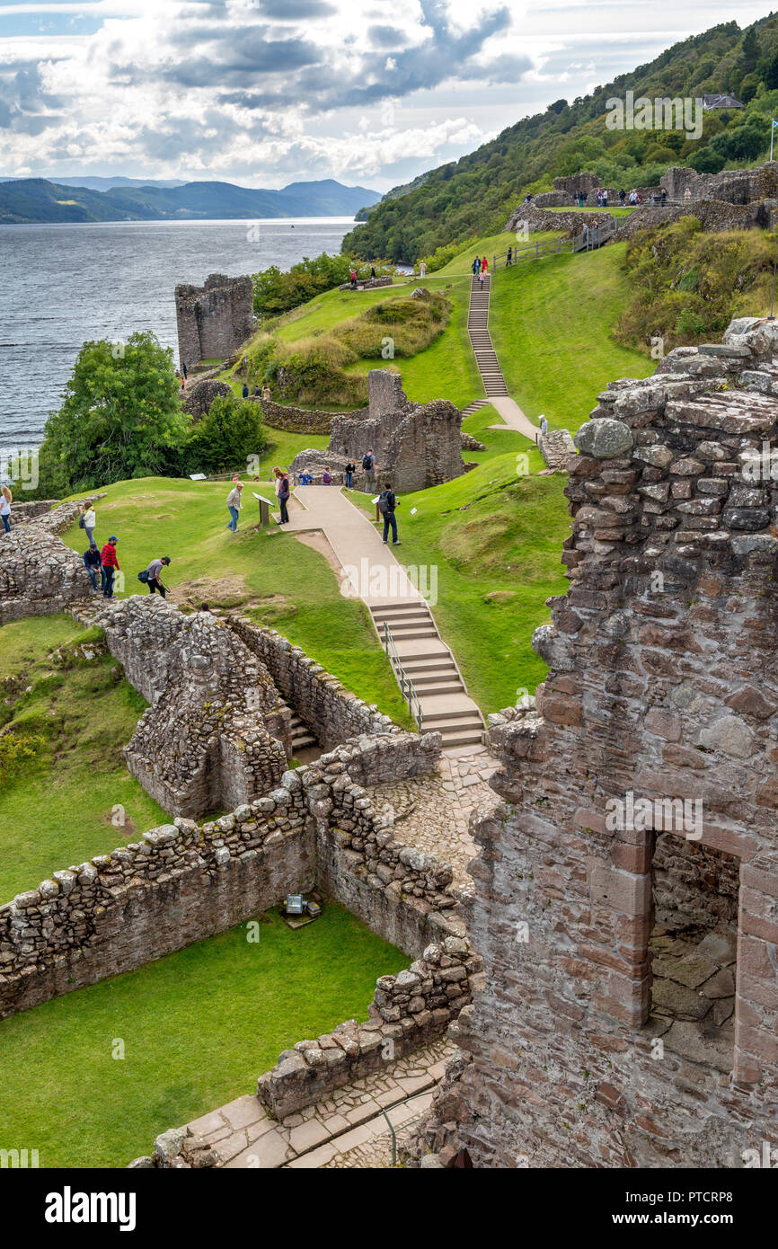 Touristen die Ruine des Urquhart Castle am Ufer des Loch Ness, Highlands, Schottland erkunden Stockfoto
