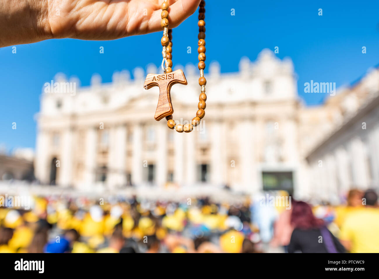 Makro Nahaufnahme von Holz- handgefertigte italienische Kreuz katholische Assisi Rosenkranz mit bokeh Hintergrund der Vatikan Kirche St. Peter's Square Basilika während der Messe o Stockfoto