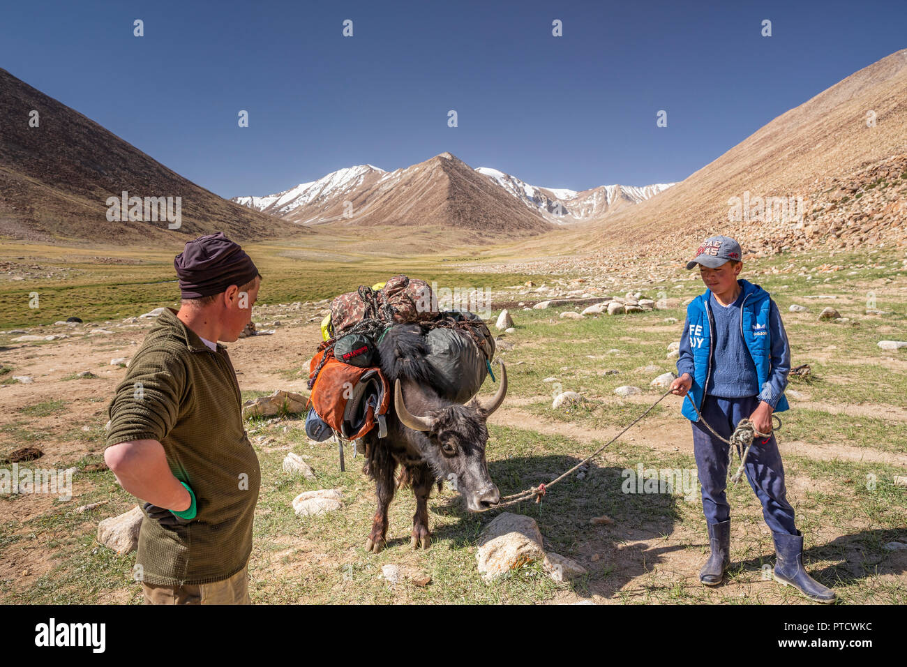 Kirgisischen Hirten und Trekke in Keng Shiber mit gepackten Yak für Trek zu Bel Airyk Pass und Kara Jilga, Pamir, Gorno-Badakhshan, Tadschikistan. Stockfoto