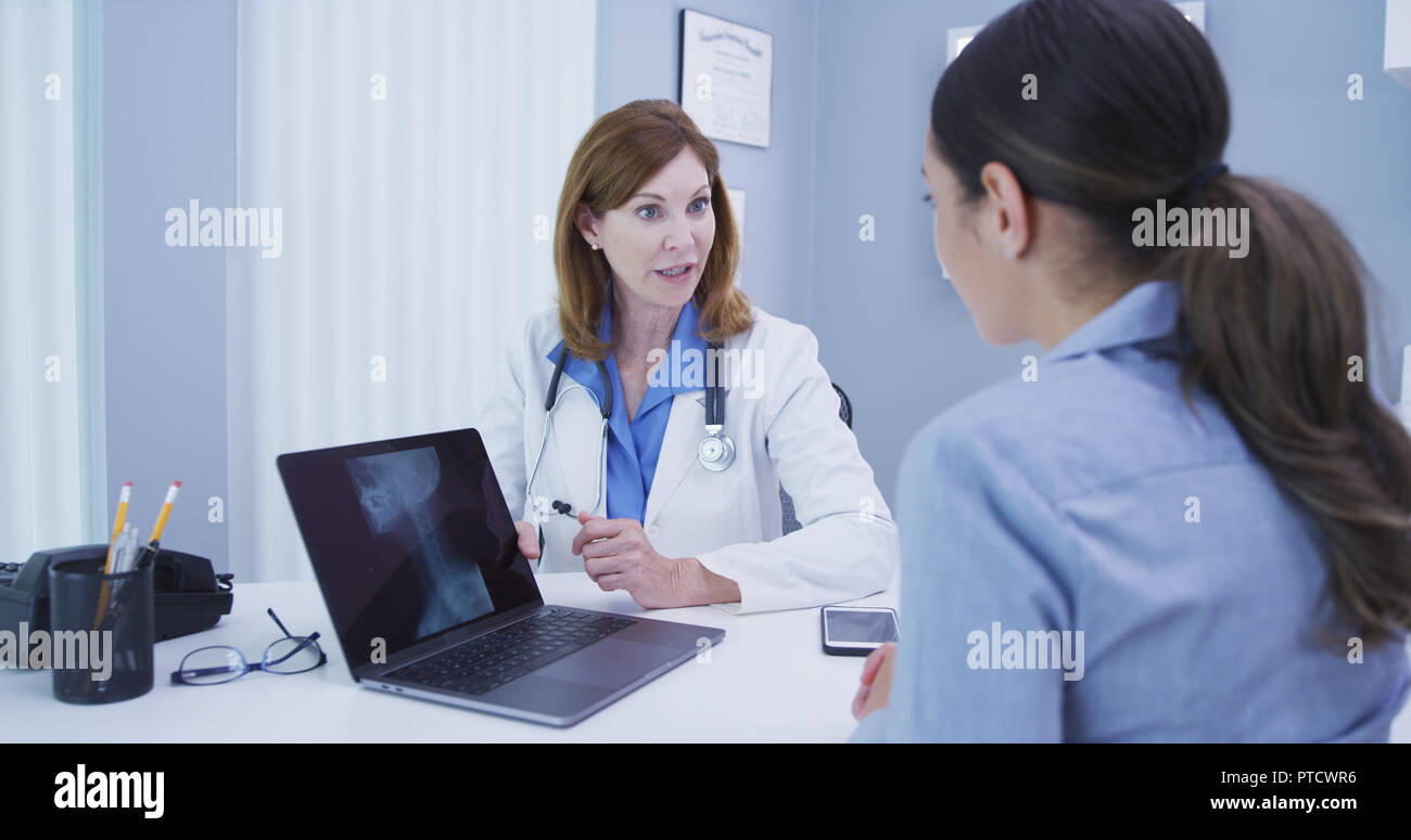 In der Nähe der charmanten leitender Arzt diskutieren Ergebnisse der Wirbelsäule Röntgen mit Patient Stockfoto