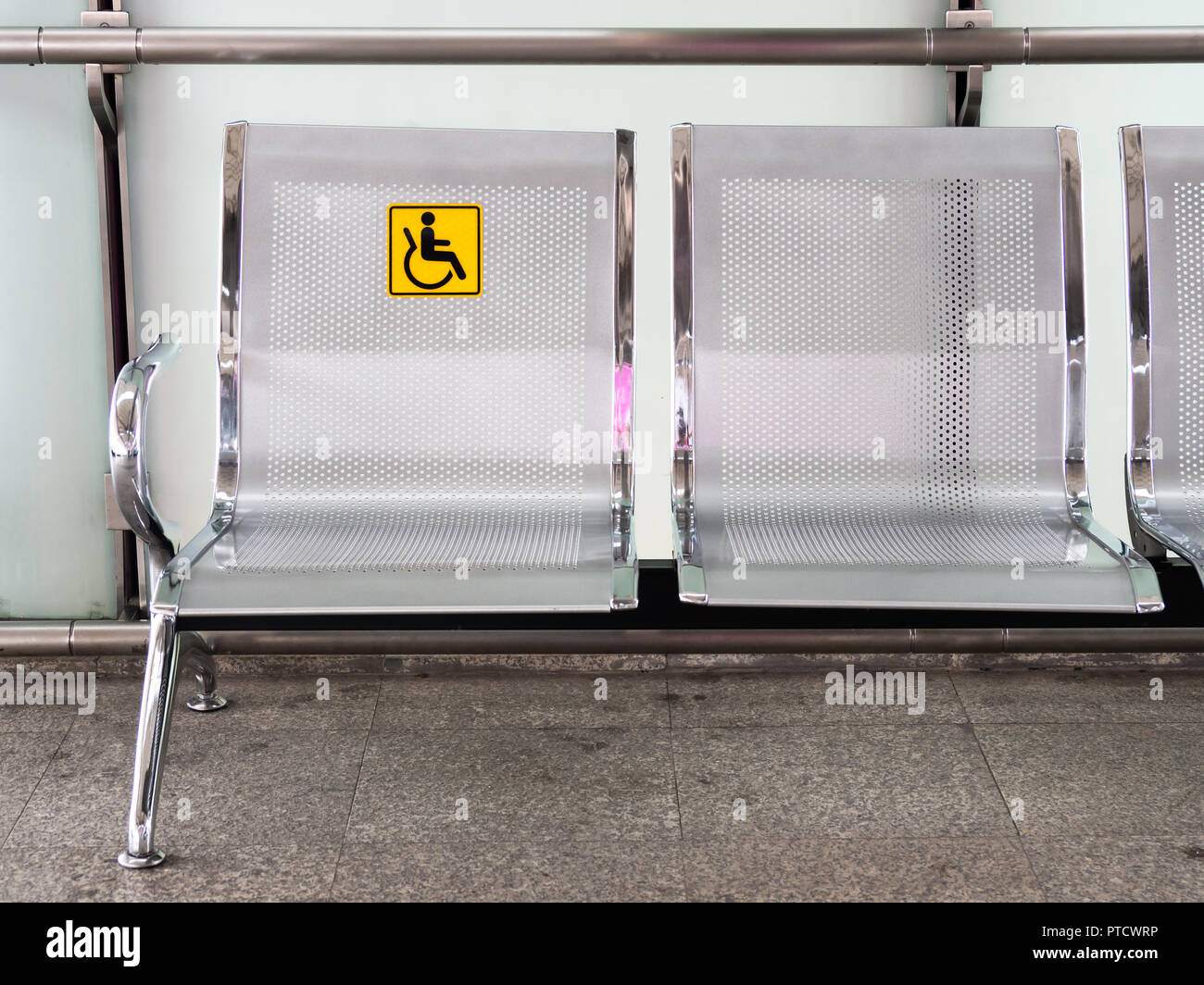 Edelstahl Stühle in den Bahnhof mit Behinderten signage die Nutzung der Bahn für Behinderte zu erleichtern. Stockfoto