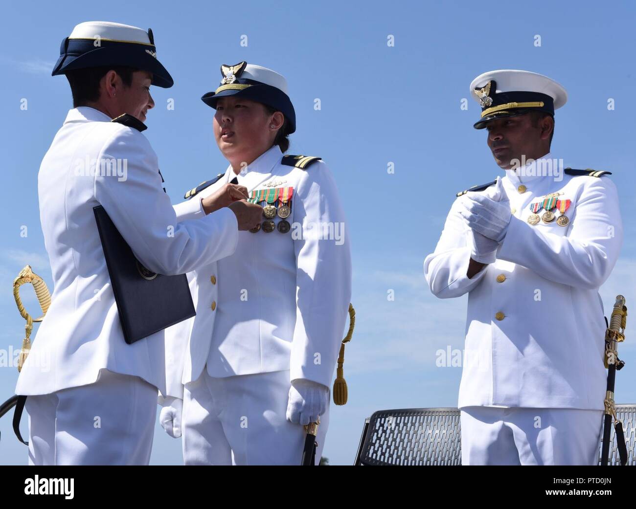 Coast Guard Kapitän Charlene L. Downey, Coast Guard Sektor Los Angeles-Long Beach kommandierenden Offizier, Stifte eine Auszeichnung auf Lt Jamie Kim während der Coast Guard Cutter Narwhal Change-of-Befehl Zeremonie in Corona Del Mar, Kalifornien, USA, 7. Juli 2017. Kim erhielt die Küstenwache Commendation Medal für ihren Dienst als Kommandierender Offizier der Cutter Narwhal. Us-Küstenwache Stockfoto