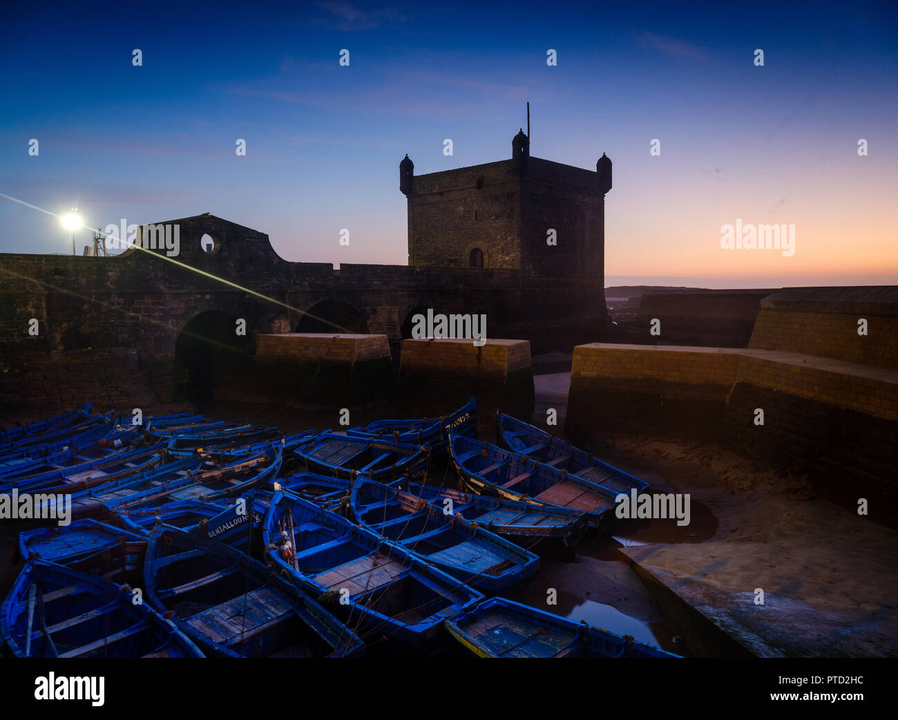 ESSAOUIRA, MAROKKO - ca. Mai 2018: Sonnenuntergang über dem Hafen von Essaouria und die berühmten Castelo Real von Mogador. Stockfoto