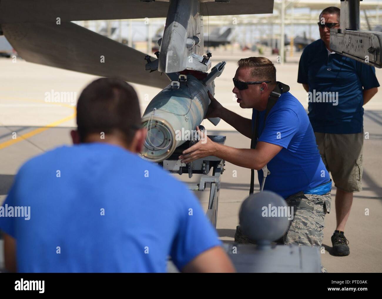 Staff Sgt. Jonathan Picher, 309Th Aircraft Maintenance Unit Load Crew Chief, sichert die GBU-12 Paveway II Verbindungen richtig während Airman 1st Class Antonio Rosario, 309Th AMU last Crew Mitglied, führt es in mit einer Antenne speichert Lkw während der vierteljährlichen Last crew Wettbewerb bei Luke Air Force Base, Ariz., 7. Juli 2017 aufzuheben. Das Ziel des Wettbewerbs war es, zwei GBU-12 s in unter 30 Minuten zu laden. Stockfoto