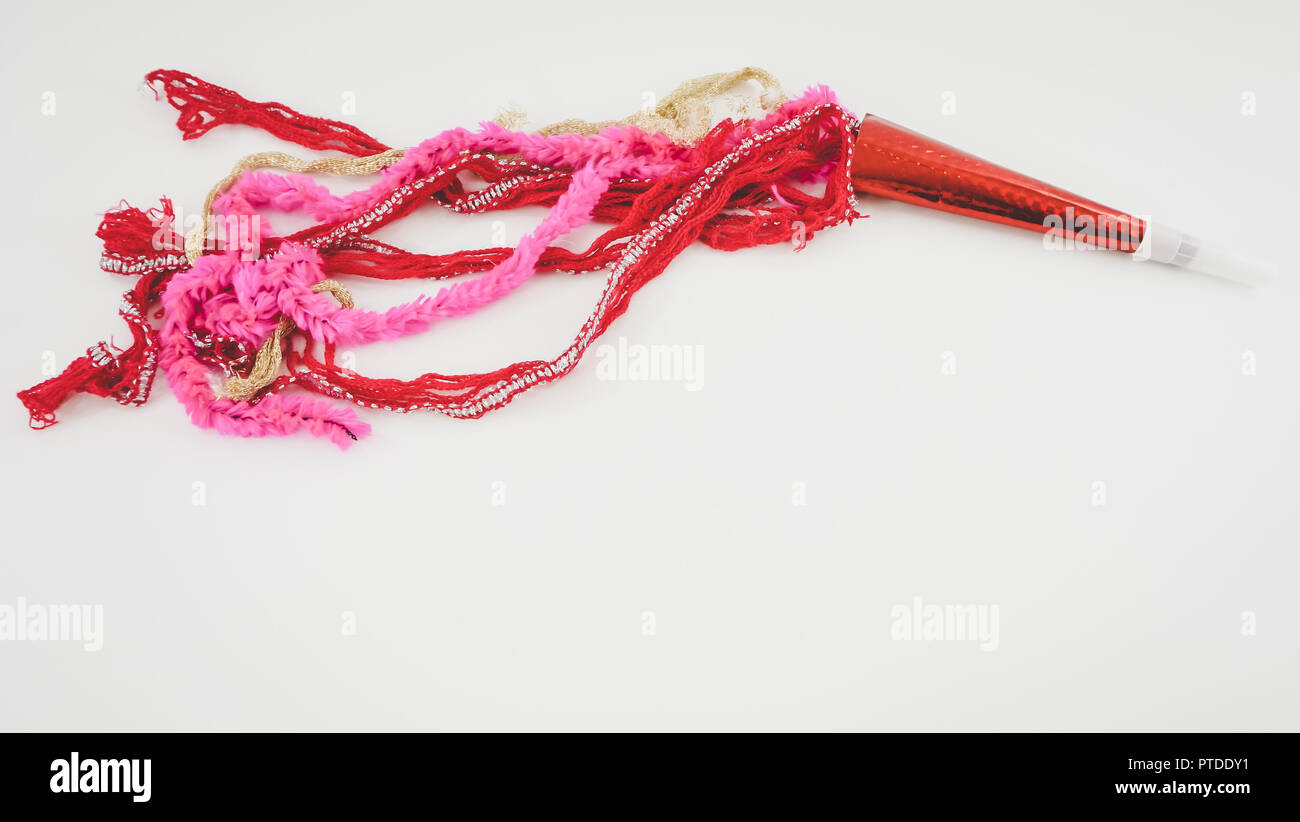 Rot und Rosa hand-made party Dekorationen mit leuchtend roten Krachmacher auf weißem Hintergrund (Ansicht von oben) perfekt zum Valentinstag oder Silvester. Stockfoto