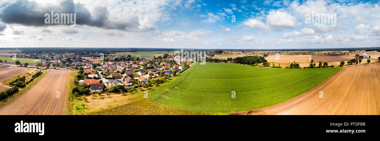 Luftaufnahme von einem kleinen Dorf in Norddeutschland mit großen Ackerflächen am Rande des Dorfes. Panorama in hoher Auflösung Stockfoto