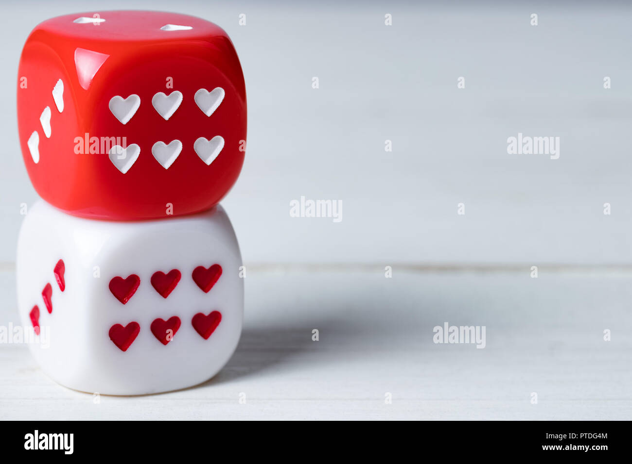 Zwei übereinander liegende rote und weiße Valentinstag Herz Würfel auf  Holz- Hintergrund. Kopieren Sie Platz auf der rechten Seite Stockfotografie  - Alamy