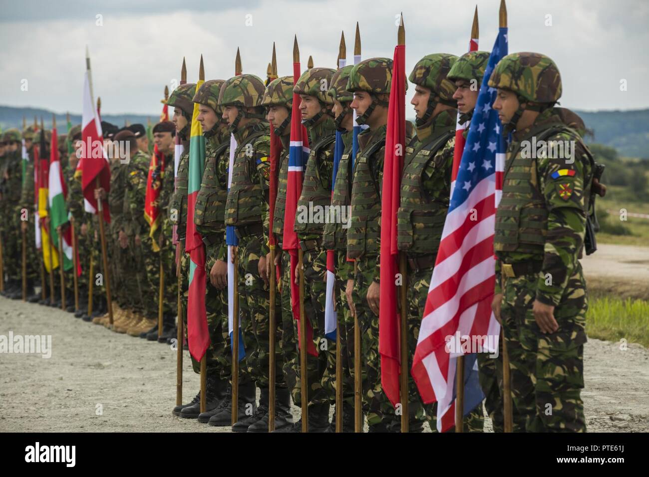 Soldaten der rumänischen Armee tragen die Getica Sabre teilnehmenden Fahnen Länder von Verehrte Besucher Tag, den 15. Juli 2017 in Cincu, Rumänien. Getica Sabre 17 ist eine von den USA geführte Fire Support Koordination und kombinierte Waffen live fire Übung umfasst sechs Verbündete und Partner Nationen mit mehr als 4.000 Soldaten. Getica Sabre 17 läuft gleichzeitig mit Säbel Guardian 17, ein US-European Command, U.S. Army Europe-led, multinationale Übung, erstreckt sich über Bulgarien, Rumänien und Ungarn mit über 25.000 service Mitglieder aus 22 NATO-Mitglieder und der Partnerstaaten. Stockfoto