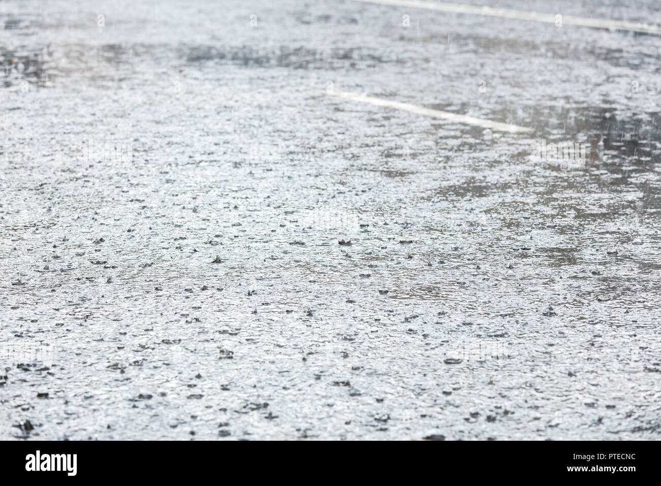 Regen in großen wasserpfütze auf Asphalt City Road plätschern Stockfoto