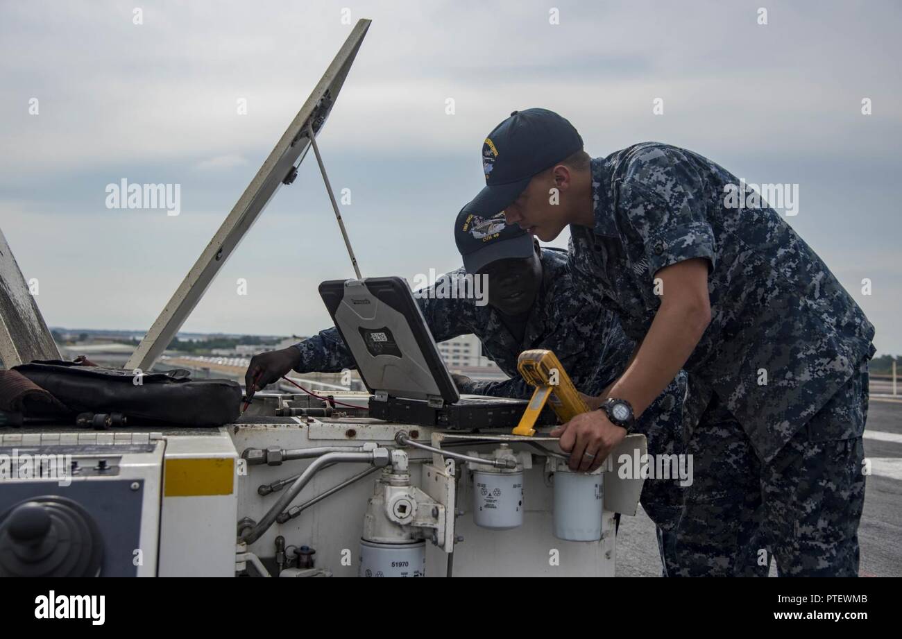 NORFOLK, Virginia (18. Juli 2017) Aviation Support Equipment Techniker 2. Klasse Gerechtigkeit Buah, die von Accra, Ghana, Links, und Aviation Support Equipment Techniker Airman Devon Climmons, von Fairborne, Ohio, beheben Sie ein Flugzeug spotting Dolly auf dem Flugdeck an Bord der Flugzeugträger USS Dwight D. Eisenhower (CVN 69) (IKE). Ike ist Pier Seite während der Erhaltungsphase der optimiert Flotte Notfallplan (OFRP). Stockfoto