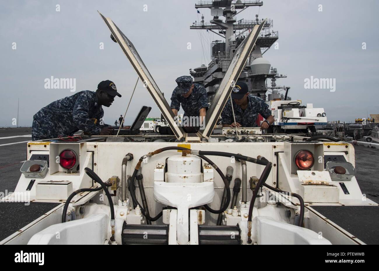 NORFOLK, Virginia (18. Juli 2017) Aviation Support Equipment Techniker 2. Klasse Gerechtigkeit Buah, die von Accra, Ghana, Links, Aviation Support Equipment Techniker 3. Klasse Michael Ward, von Rancho Santa Margarita, Calif. und Aviation Support Equipment Techniker Airman Devon Climmons, von Fairborne, Ohio, beheben Sie ein Flugzeug spotting Dolly auf dem Flugdeck an Bord der Flugzeugträger USS Dwight D. Eisenhower (CVN 69) (IKE). Ike ist Pier Seite während der Erhaltungsphase der optimiert Flotte Notfallplan (OFRP). Stockfoto