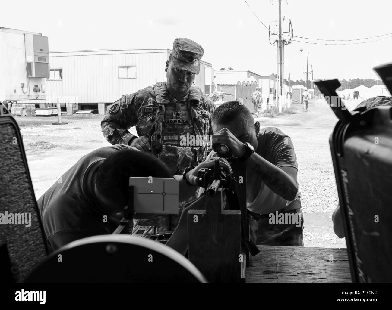 Spc. Corbin Schick und SPC. Brian Bui, sowohl von Unternehmen D, 2.BATAILLON, 151 Infanterie Regiment, 76th Infantry Brigade Combat Team, 38th Infantry Division, Indiana Army National Guard, installiert eine Laser Sendeanlage auf dem M4 Carbine für Sgt. 1. Klasse Jose Rosario, von C Firma, 1 Battalion, 65th Infantry Regiment, Puerto Rico Army National Guard, auf Forward Operating Base Krieger an das Joint Readiness Training Center in Fort Polk, Louisiana, Dienstag, 18. Juli 2017. Der laser Sender ermöglichen die Waffen Hits auf gegensätzlichen Kräfte während Wargames bei JRTC zu simulieren. Stockfoto