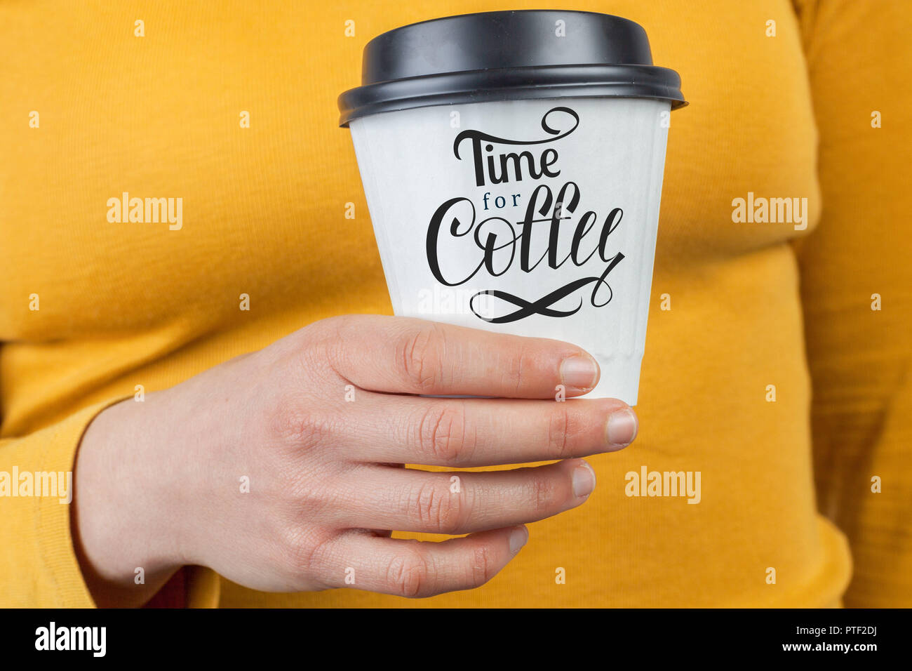 Weibliche Hand, die eine verfügbare weiße Tasse mit Zeit für Kaffee hand Schrift Stockfoto
