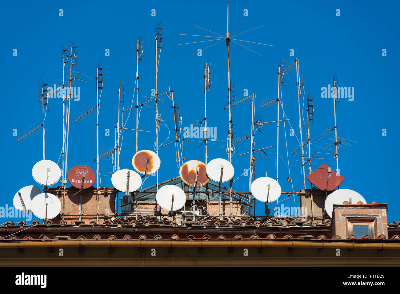 Rostige alte Antennen und Satellitenschüsseln auf einem Gebäude in Trastevere, Rom, Italien. Stockfoto