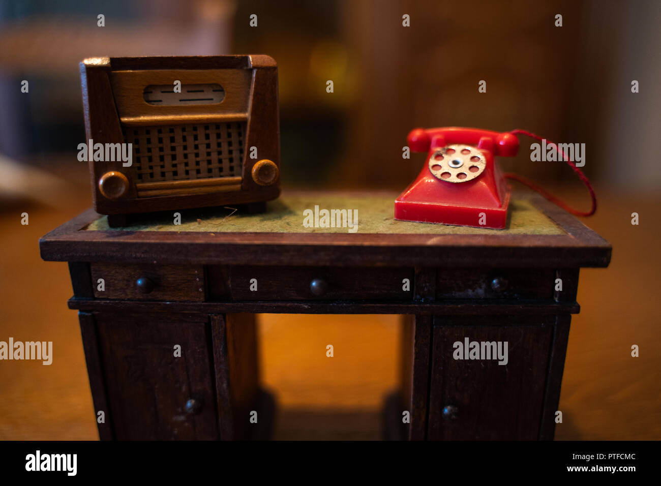 Alte Dollhouse Radio und dem roten Telefonsymbol auf Tisch Stockfoto